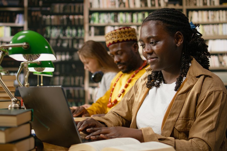 A student working on a laptop at a library desk